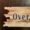 Zoom in to the left part of the Personalised Driftwood Shaped Metal Sign with wooden effect and text Overthink? Never!
