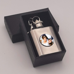 Personalised stainless steel hip flask keyring displayed on a black gift box, personalised with a photo of a wedding couple